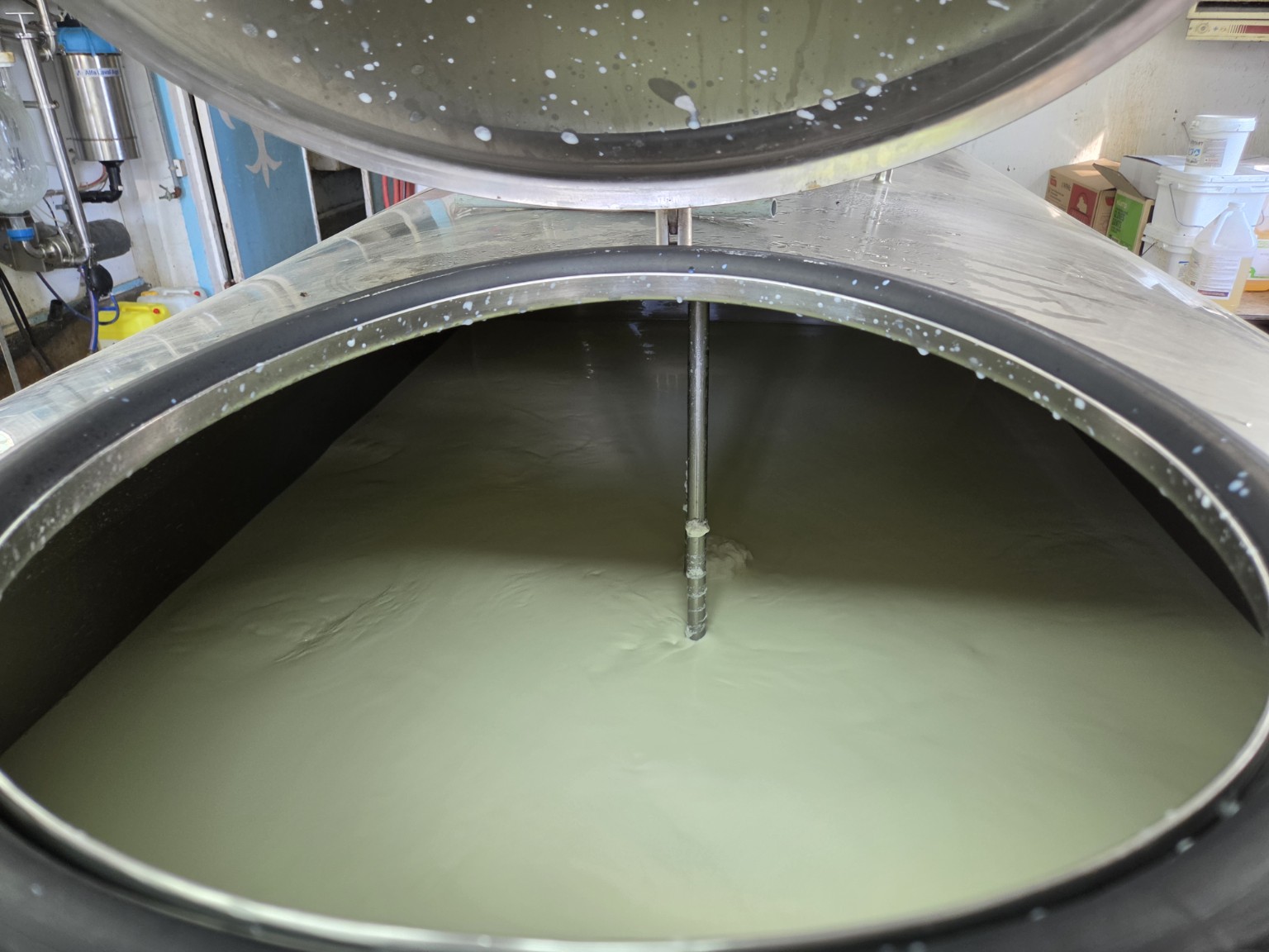 Open refrigerated bulk milk tank on a dairy farm