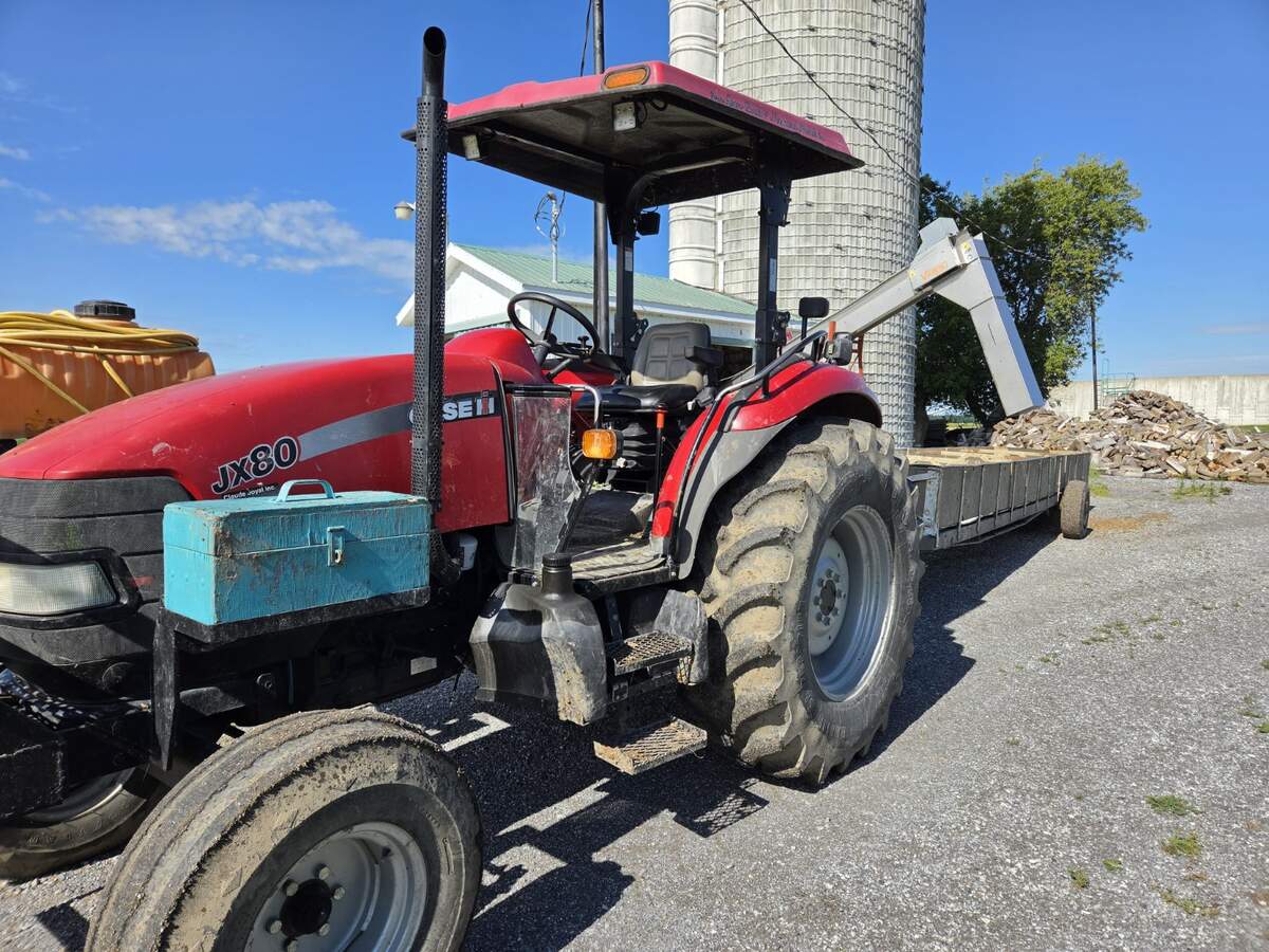 Case IH JX80 attelé au chariot utilisé pour nourrir les taures au parc